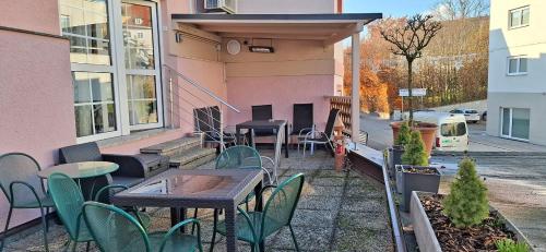 a patio with tables and chairs in front of a pink building at Hotel Schlair in Kremsmünster
