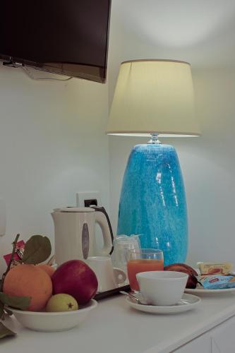 a table with a plate of fruit and a blue vase at Hotel Aurora in Amalfi