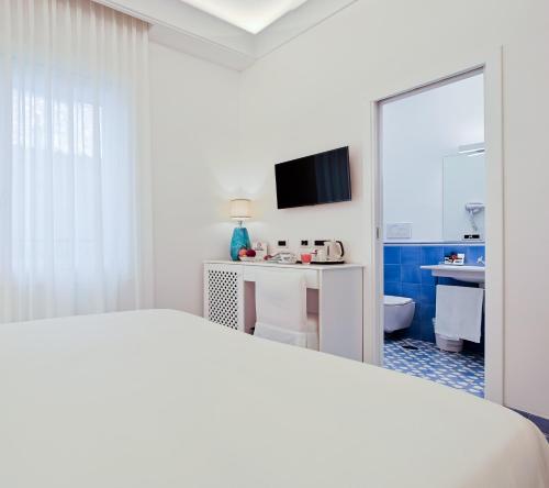 a hotel room with a bed and a bathroom at Hotel Aurora in Amalfi