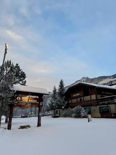 a snow covered building with a sign that reads ski station at Hotel Sella Ronda Serenella in Campitello di Fassa