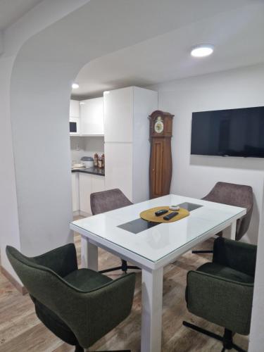 a dining room with a white table and chairs at small apartment for two in Brus