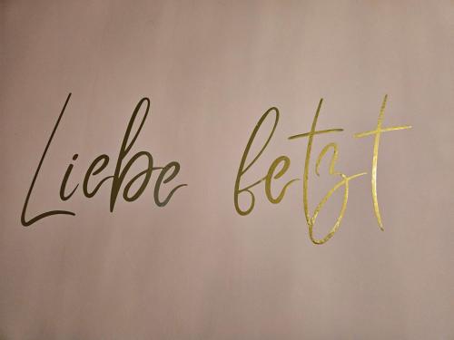 a sign with the word hello lettuce written on a wall at Villa Elbling in Radebeul