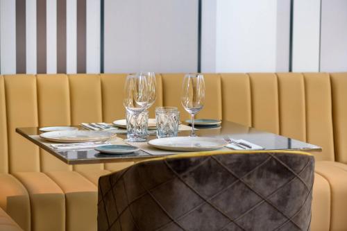 a table with wine glasses and plates on it at AC Hotel Avenida de América by Marriott in Madrid