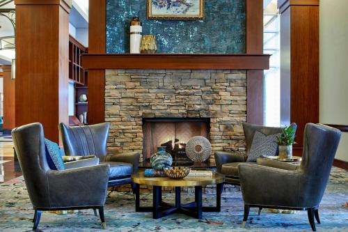 a lobby with chairs and a stone fireplace at Renaissance Montgomery Hotel & Spa at the Convention Center in Montgomery