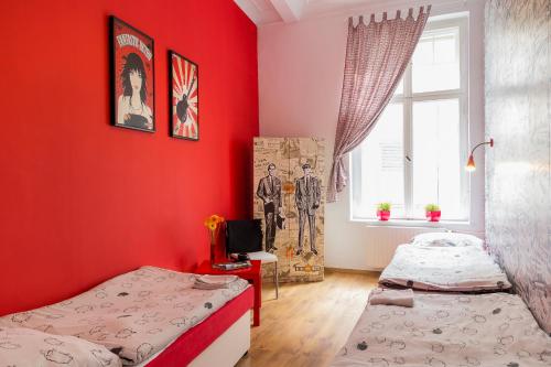 two beds in a room with red walls at Retro Hostel in Poznań