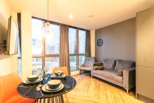 a living room with a table and a couch at Stunning 2BED Flat in Central Location w Security in Manchester