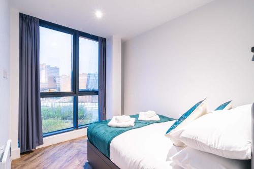 a bedroom with two beds and a large window at Stunning 2BED Flat in Central Location w Security in Manchester