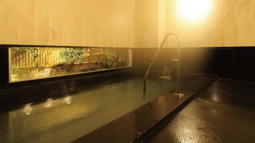盐尻市AB Hotel Shiojiri的带浴缸和窗户的浴室