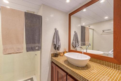 a bathroom with a sink and a mirror and a tub at Flat Eco Paradise Cumbuco - Ap 113 in Cumbuco