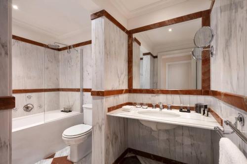 a bathroom with a toilet and a sink and a tub at Renaissance Tuscany Il Ciocco Resort & Spa in Barga