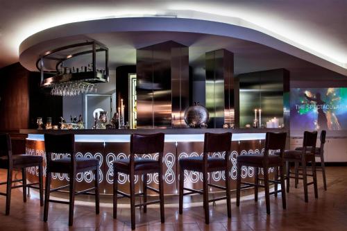 a bar with a bunch of chairs in a room at Renaissance Tuscany Il Ciocco Resort & Spa in Barga