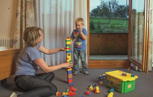a woman and a boy playing with a lego toy at Landgasthof Adler Pelzmühle in Biederbach Baden-Württemberg
