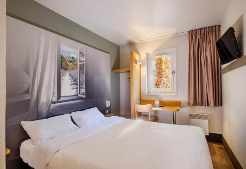 a hotel room with a white bed and a window at B&B HOTEL Villeneuve Loubet Plage in Villeneuve-Loubet