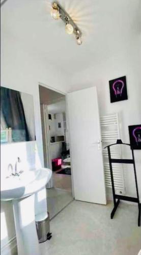 une salle de bain avec un lavabo blanc et un miroir dans l'établissement Terrasse front de mer, à Villers-sur-Mer