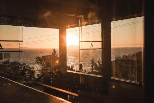 a room with a window with a view of the ocean at Colonna Galapagos Garden Hotel in Búzios