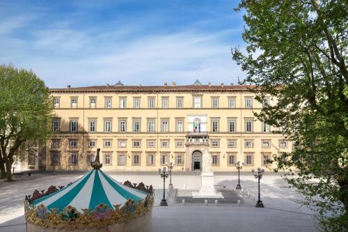 a large building with a tent in front of it at Grand Universe Lucca, Autograph Collection in Lucca