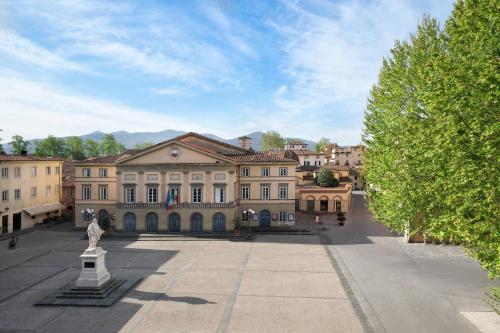 a large building with a statue in front of it at Grand Universe Lucca, Autograph Collection in Lucca