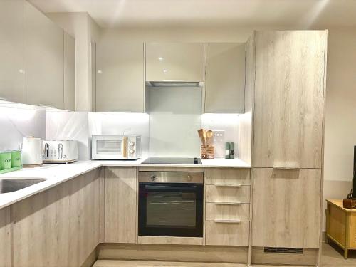 a kitchen with white cabinets and a stove top oven at Poole Quay Seaside Escape-free parking 3 mins away in Poole