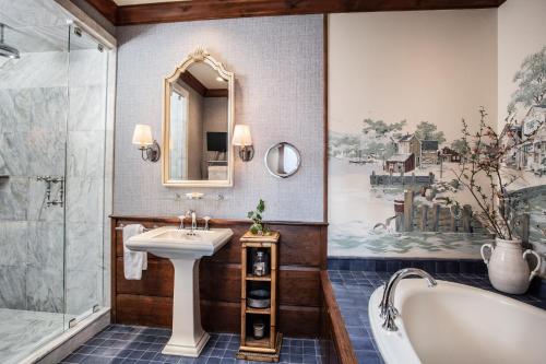 a bathroom with a bath tub and a sink and a bath tub at The Chanler at Cliff Walk in Newport
