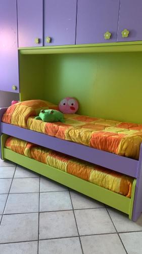 a bunk bed in a room with a green wall at Appartamente moderno e accessoriato. in Pula