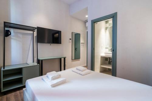 a bedroom with a large white bed and a bathroom at VLC HOST - Reina 168 in Valencia