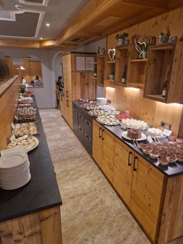 a large kitchen with many plates of food on the counters at Hotel Tonnerhof in Racines