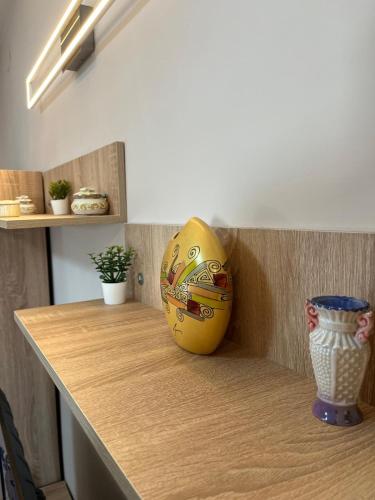a yellow vase sitting on top of a wooden counter at Apartman KVINS in Kruševac