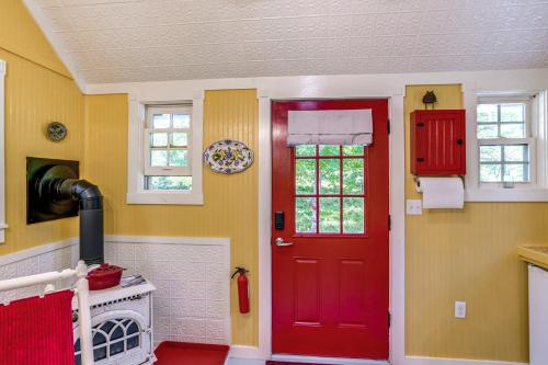 a red door in a kitchen with yellow walls at Studio with Trail Access about 10 Mi to Brattleboro! in Bernardston