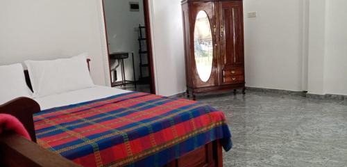 a bedroom with a bed with a colorful blanket at Conch Villa in Kalutara