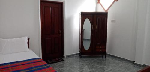 a bedroom with a bed and a dresser and a mirror at Conch Villa in Kalutara