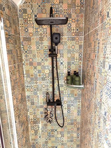 a shower with a shower head on a tiled wall at Casa Moara - Downtown Duplex House in Porto