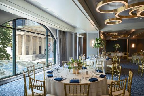 a dining room with tables and chairs and a large window at Renaissance Philadelphia Downtown Hotel in Philadelphia