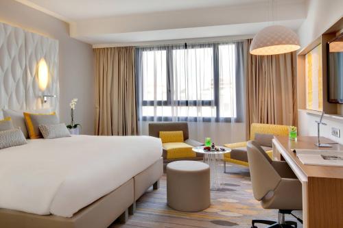 a hotel room with a large bed and a desk at Renaissance Aix-en-Provence Hotel in Aix-en-Provence