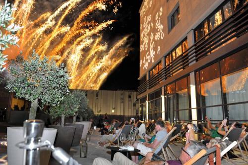 a group of people sitting in chairs in front of a building at Renaissance Aix-en-Provence Hotel in Aix-en-Provence