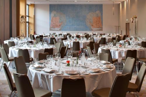a conference room with white tables and chairs at Renaissance Aix-en-Provence Hotel in Aix-en-Provence