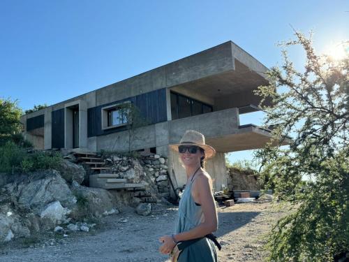 a woman in a hat standing in front of a house at Escapada romántica en El Leon in San Javier