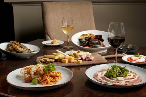 a table with plates of food and glasses of wine at The Battle House Renaissance Mobile Hotel & Spa in Mobile