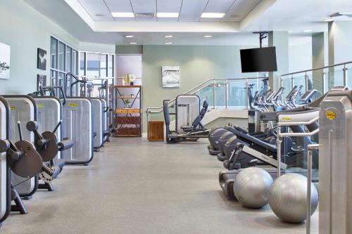a gym with rows of exercise equipment and a flat screen tv at The Battle House Renaissance Mobile Hotel & Spa in Mobile