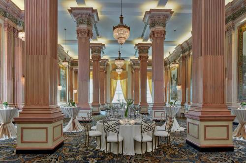 a banquet hall with tables and chairs and columns at The Battle House Renaissance Mobile Hotel & Spa in Mobile