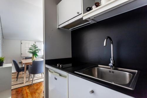 a kitchen with a sink and a table at Citybreak-apartments Lapa in Porto