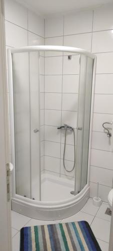 a shower with a glass door in a bathroom at Apartmani METRO in Loznica