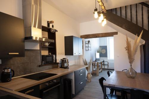 a kitchen with a counter top and a dining table at Maison COSY et CHALEUREUSE au centre ville in Mont-de-Marsan