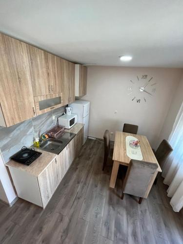 a small kitchen with a table and a sink at Apartman KVINS in Kruševac