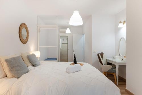 ein weißes Schlafzimmer mit einem großen Bett mit einer Katze drauf in der Unterkunft Villa Berkana De Lujo Con Piscina in Playa Honda