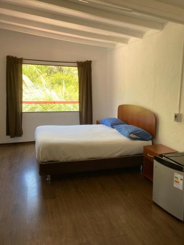 a bedroom with a large bed with a window at Cottages by the river in Rivadavia
