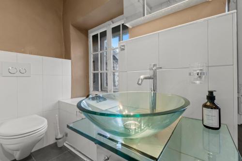 a bathroom with a glass sink and a toilet at Studio charmant dans la vieille ville de Fribourg in Fribourg