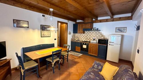 a kitchen with a table and chairs and a refrigerator at Agriturismo Lambra La Casa Del Sol in Asiago