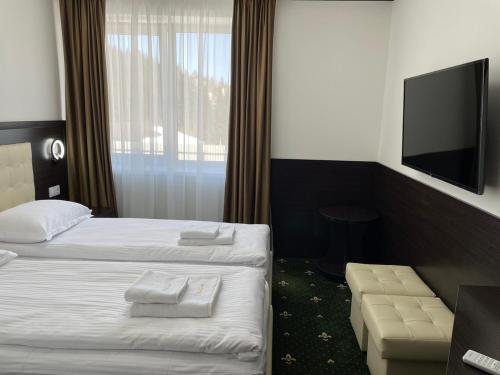 a hotel room with two beds and a flat screen tv at Готельний комплекс Парламент, Яблуниця in Yablunytsya