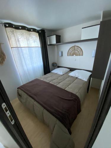 une chambre avec un grand lit et une fenêtre dans l'établissement V&B Mobil-Home, à Saillagouse