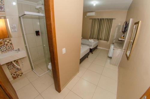 a small bathroom with a toilet and a shower at Pousada 4 Estações in Penha